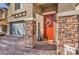 Inviting front entrance with stone columns, a red door adorned with a wreath, and a paved walkway at 4442 Solitude Falls Ave, North Las Vegas, NV 89084