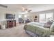 This main bedroom has carpet, a ceiling fan, and windows offering ample natural light at 4442 Solitude Falls Ave, North Las Vegas, NV 89084