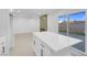 Spacious kitchen island with white countertops, storage cabinets and an adjacent living area at 4629 Alta Dr, Las Vegas, NV 89107