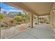 Covered patio overlooks a serene backyard with a rock waterfall, mature trees, and a sitting area at 5835 Farmhouse Ct, Las Vegas, NV 89141
