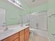 Bathroom with double sink vanity, shower-tub combo with sliding glass doors, and bright lighting at 5835 Farmhouse Ct, Las Vegas, NV 89141