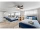 Bright bedroom featuring two beds, a ceiling fan, large mirror closet doors, and plenty of natural light at 6121 Dayton Cir, Las Vegas, NV 89107