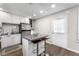 A modern kitchen features an island with breakfast bar, stainless steel refrigerator and white cabinetry at 6121 Dayton Cir, Las Vegas, NV 89107