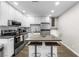 Kitchen features modern appliances, an island with breakfast bar, and white cabinetry at 6121 Dayton Cir, Las Vegas, NV 89107