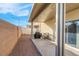 Covered patio with a grill, table, chairs, and a brick wall, ideal for outdoor dining and relaxation at 6461 Karlsen Ct, Las Vegas, NV 89122