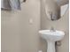Cozy half bathroom features a pedestal sink with round mirror and neutral color scheme at 6461 Karlsen Ct, Las Vegas, NV 89122