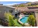 Backyard pool area featuring a spa, lounge area, outdoor kitchen, putting green, and desert landscaping at 6491 Wild Blue Ct, Las Vegas, NV 89135