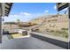 Expansive backyard featuring a patio with plush seating and direct access to stunning desert mountain views at 6491 Wild Blue Ct, Las Vegas, NV 89135
