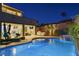 Backyard at night with a built-in bbq, fireplace, privacy landscaping, and a beautiful pool at 6491 Wild Blue Ct, Las Vegas, NV 89135