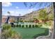 A stunning backyard featuring a pool, putting green, lush landscaping and mountain views at 6491 Wild Blue Ct, Las Vegas, NV 89135