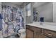 Cozy bathroom featuring a shower-tub combo, decorative curtain and modern dark wood vanity at 6491 Wild Blue Ct, Las Vegas, NV 89135
