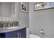Powder room with navy blue vanity, granite counter, modern fixtures, and decorative wall art at 6491 Wild Blue Ct, Las Vegas, NV 89135