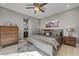 Beautifully staged bedroom with a ceiling fan, a chest of drawers, and a glimpse into an attached bathroom at 6491 Wild Blue Ct, Las Vegas, NV 89135