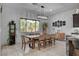 Bright dining room featuring a large window, modern lighting, and seating for eight at 6491 Wild Blue Ct, Las Vegas, NV 89135