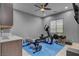 A home exercise room featuring exercise equipment, blue floor mat, kitchenette and ceiling fan at 6491 Wild Blue Ct, Las Vegas, NV 89135
