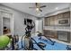 A home exercise room featuring exercise equipment, blue floor mat, kitchenette and ceiling fan at 6491 Wild Blue Ct, Las Vegas, NV 89135