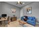 A cozy office with a blue sofa, a wood desk, modern lighting and neutral walls at 6491 Wild Blue Ct, Las Vegas, NV 89135