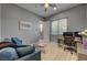 A stylish home office with a blue sofa, a wood desk, modern lighting and neutral walls at 6491 Wild Blue Ct, Las Vegas, NV 89135