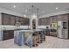 Modern kitchen featuring stainless steel appliances, a stylish island with seating, and elegant pendant lighting at 6491 Wild Blue Ct, Las Vegas, NV 89135