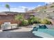 Beautiful pool area with an outdoor kitchen, spa and lush desert landscaping in the background at 6491 Wild Blue Ct, Las Vegas, NV 89135