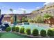 Stunning backyard pool with an integrated spa, rock waterfall feature, and beautiful landscaping at 6491 Wild Blue Ct, Las Vegas, NV 89135
