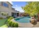 Inviting backyard pool with lush landscaping, a built-in spa, and an outdoor kitchen at 6491 Wild Blue Ct, Las Vegas, NV 89135