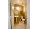 Cozy half-bathroom features a pedestal sink, oval mirror, and tile floors at 6628 Martinsville Pl, Las Vegas, NV 89110