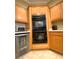 Built-in double oven with warm wood cabinets and a wine fridge at 6628 Martinsville Pl, Las Vegas, NV 89110