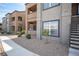Apartment building exterior with neutral colors, small bushes, and a sidewalk at 6650 W Warm Springs Rd # 1079, Las Vegas, NV 89118