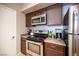Modern kitchen features stainless steel appliances, dark cabinetry, and plenty of counter space for cooking and storage at 6650 W Warm Springs Rd # 1079, Las Vegas, NV 89118