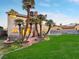 A spacious backyard featuring a well-manicured lawn, patio and mature palm trees providing shade and tropical ambiance at 6712 Kittery Dr, Las Vegas, NV 89107