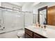 Well-lit bathroom features a shower and tub combination, a dark brown cabinet with white sink and mirror at 6712 Kittery Dr, Las Vegas, NV 89107