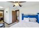 Bright bedroom with a ceiling fan, view to the bathroom, and a blue painted headboard and frame at 6712 Kittery Dr, Las Vegas, NV 89107