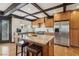 Kitchen featuring an island with seating, modern appliances, wood cabinets, and a stainless steel fridge at 6712 Kittery Dr, Las Vegas, NV 89107