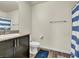 Bathroom featuring granite countertops, dark wood cabinetry and a shower with a blue and white curtain at 7017 Magenta Moon St, North Las Vegas, NV 89086