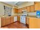 A full kitchen with white appliances and wood cabinetry at 7054 Burcot Ave # G40, Las Vegas, NV 89156