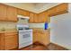 A kitchen with white appliance, wood cabinets and laminate countertops at 7054 Burcot Ave # G40, Las Vegas, NV 89156