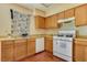 A kitchen featuring wood cabinets, laminate countertops, a white stove, and wood-look flooring at 7054 Burcot Ave # G40, Las Vegas, NV 89156