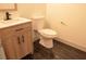 Modern bathroom showcasing a stylish wood-grain vanity and black marble floors, offering a clean and elegant design at 8101 Spur Ct, Las Vegas, NV 89145
