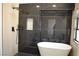 Elegant bathroom featuring a soaking tub, black marble tile, and modern fixtures at 8101 Spur Ct, Las Vegas, NV 89145