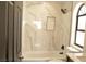 Well-lit bathroom with white marble style tile, bathtub, shower and window at 8101 Spur Ct, Las Vegas, NV 89145