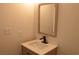 Modern half bathroom with wood-grain vanity, elegant mirror and black faucet, creating a stylish and functional space at 8101 Spur Ct, Las Vegas, NV 89145