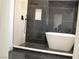 Modern bathroom featuring a walk-in shower with black marble tile and soaking tub at 8101 Spur Ct, Las Vegas, NV 89145