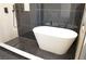 Bathroom featuring black marble tile, modern tub, and black hexagon tile floors at 8101 Spur Ct, Las Vegas, NV 89145