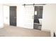 Bedroom with fireplace, carpet, and sliding barn door leading to the bathroom at 8101 Spur Ct, Las Vegas, NV 89145