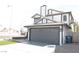 View of the exterior showcasing a modern home with gray garage door and white siding, plus a unique roof at 8101 Spur Ct, Las Vegas, NV 89145