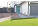 Charming home featuring an inviting teal door, a well-maintained front yard with artificial turf, and a gray painted garage at 8101 Spur Ct, Las Vegas, NV 89145