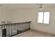 Bright hallway with light wood floors, black railing, a modern light fixture and a window letting in natural light at 8101 Spur Ct, Las Vegas, NV 89145