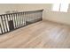 Bright hallway with light wood floors and black railing leading to other rooms in the home at 8101 Spur Ct, Las Vegas, NV 89145
