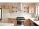 Kitchen showcasing stainless steel appliances, shaker cabinets, quartz countertop, open shelving, and herringbone backsplash at 8101 Spur Ct, Las Vegas, NV 89145